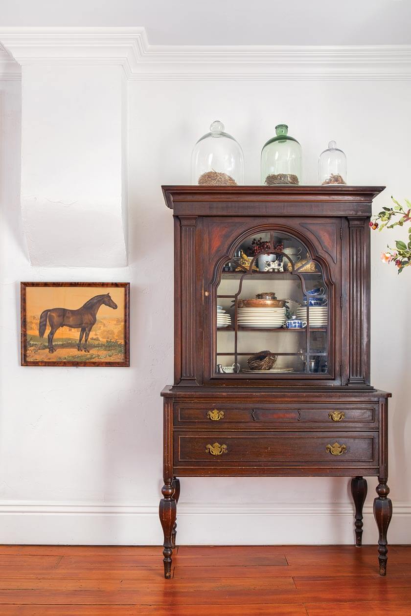 vintage painting of a horse beside antique hutch