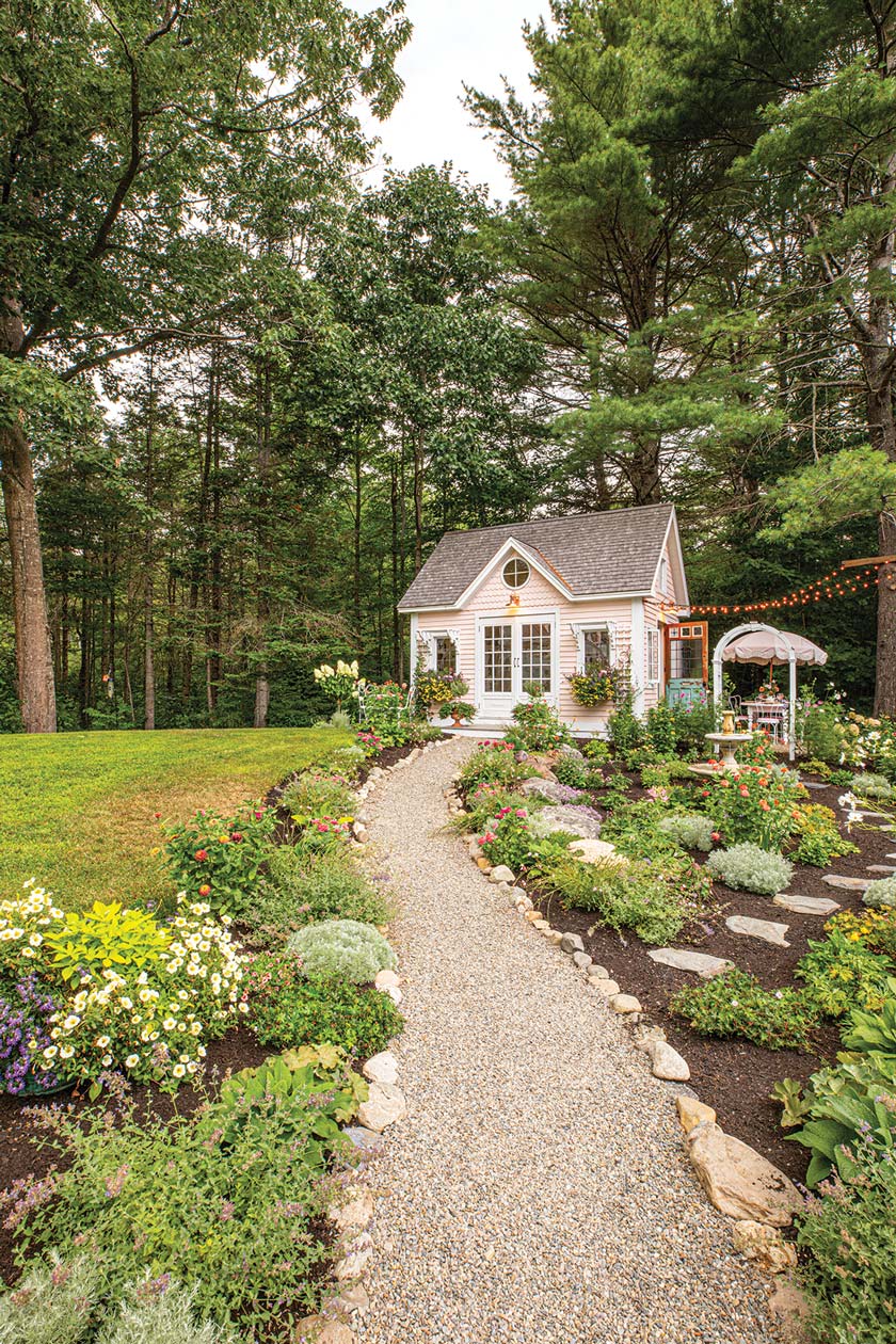 garden path leading to pink cottage style she shed in Maine home