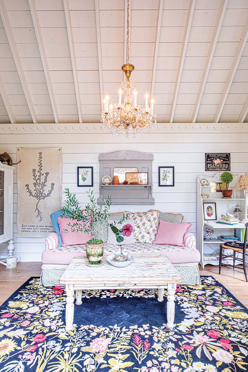 interior of she shed with floral rug sofa and chandelier