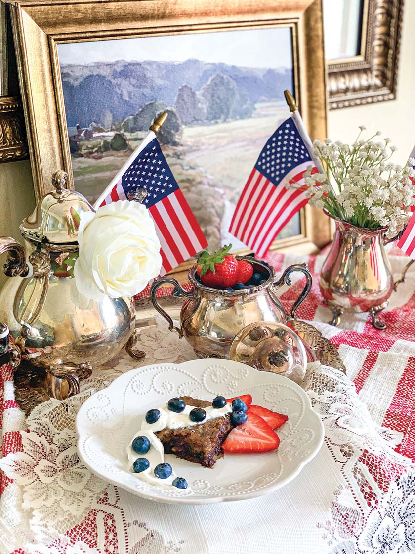 4th of July side table decor with small flags and plate of blueberries and strawberries