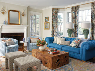 long view of living room showing mix of pattern and color in curtains decor and furniture