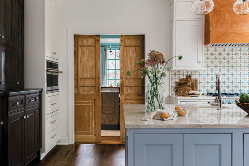sliding wood doors partitioning off kitchen in renovated kitchen with French blue