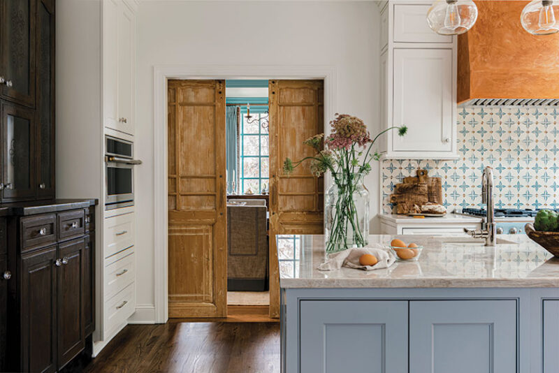 sliding wood doors partitioning off kitchen in renovated kitchen with French blue