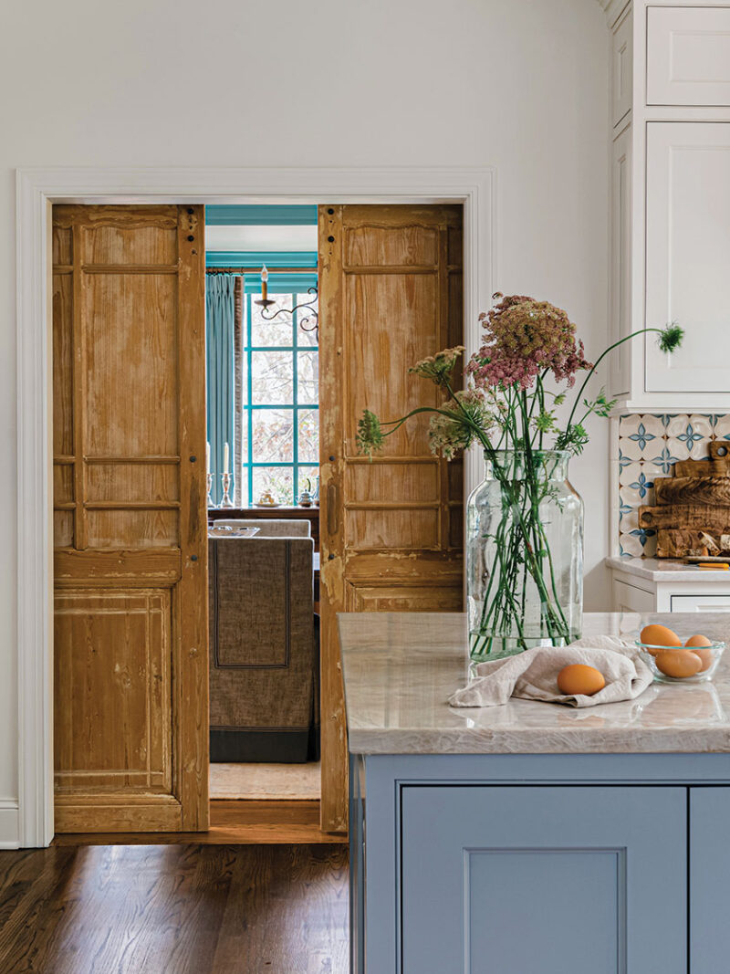 sliding wood doors partitioning off kitchen in renovated kitchen with French blue