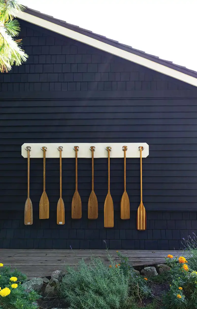 paddles hanging on dark gray exterior of dock in Lake Muskoka