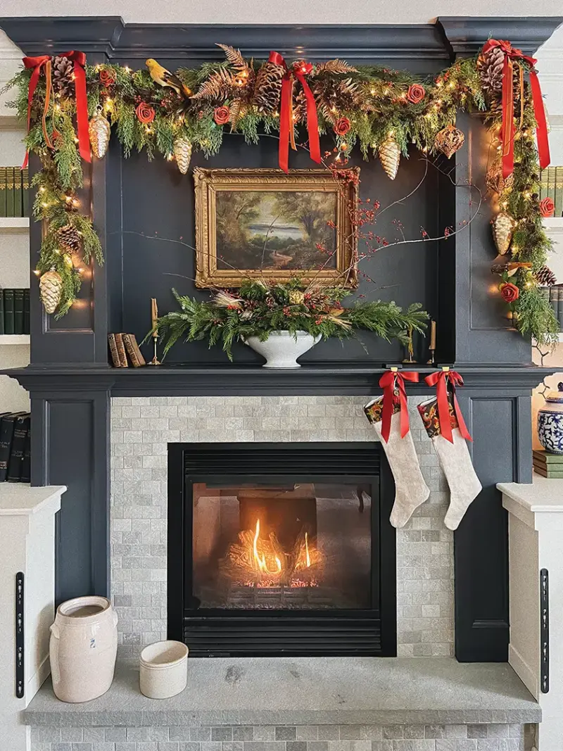 neutral fireplace with garland of pine and pinecones and red ribbon
