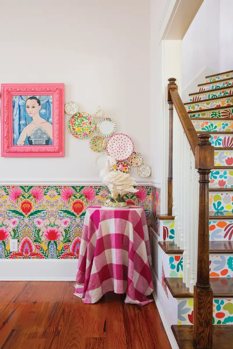 colorful dishware serves as wall art as well as bright floral wallpaper on half wall