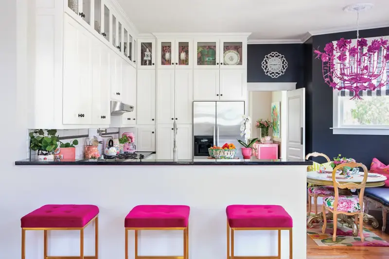 dining room with navy blue accent wall and fuschia chandelier