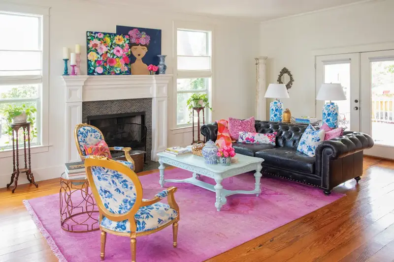 living room with bright pink rug and floral paintings