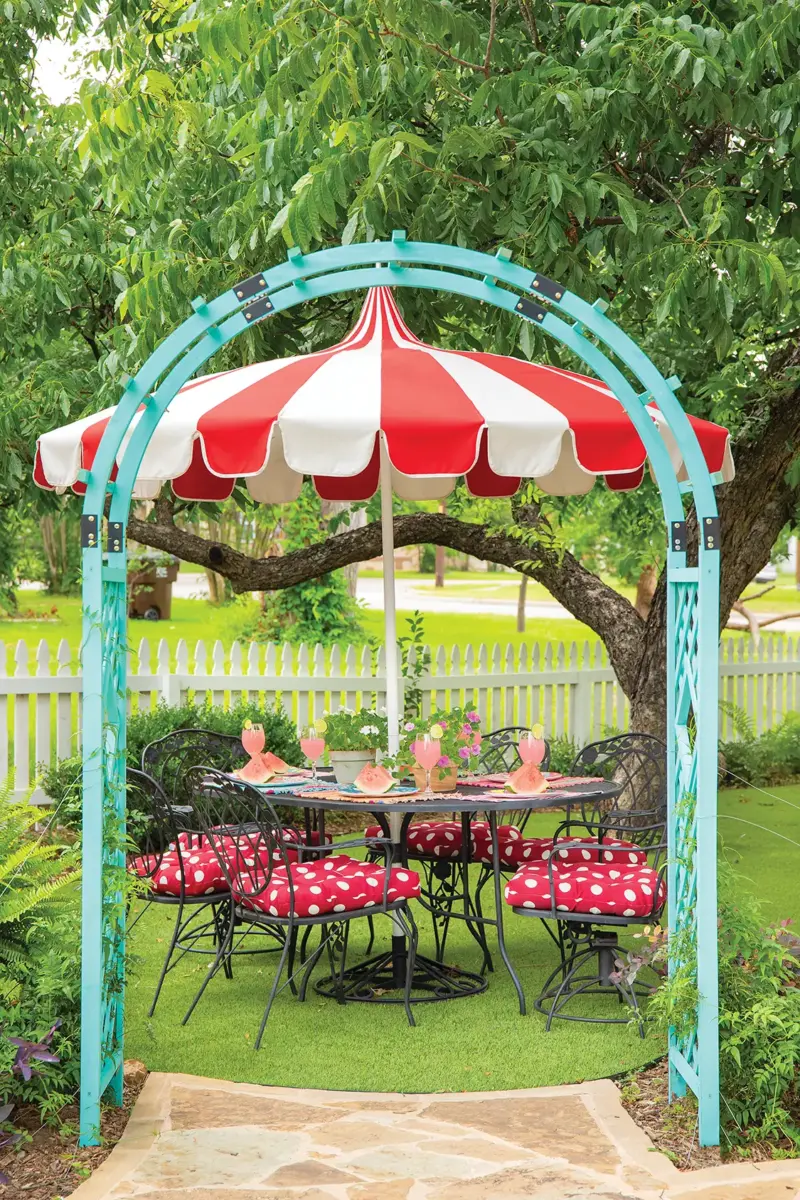 turquoise archway and red and white outdoor dining cushions and parasol