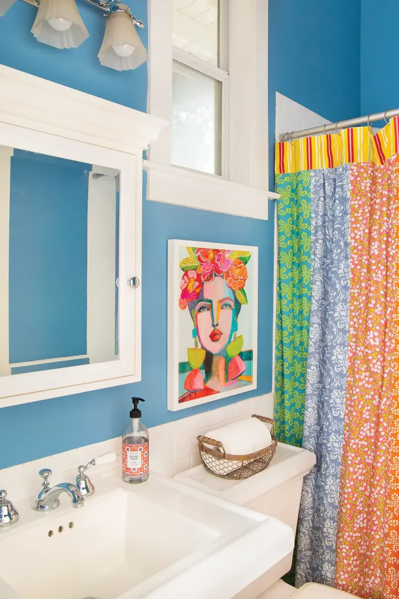 multi-colored shower curtain and blue walls in bathroom