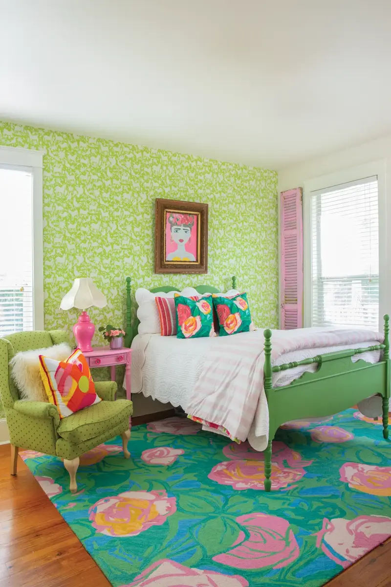 bedroom with green wallpaper and bedframe with pink accents