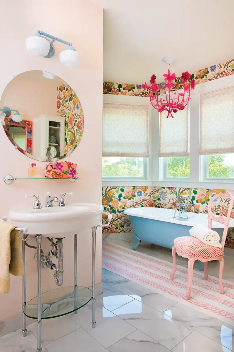 bathroom with hot pink chandelier, powder blue clawfoot tub and floral wallpaper