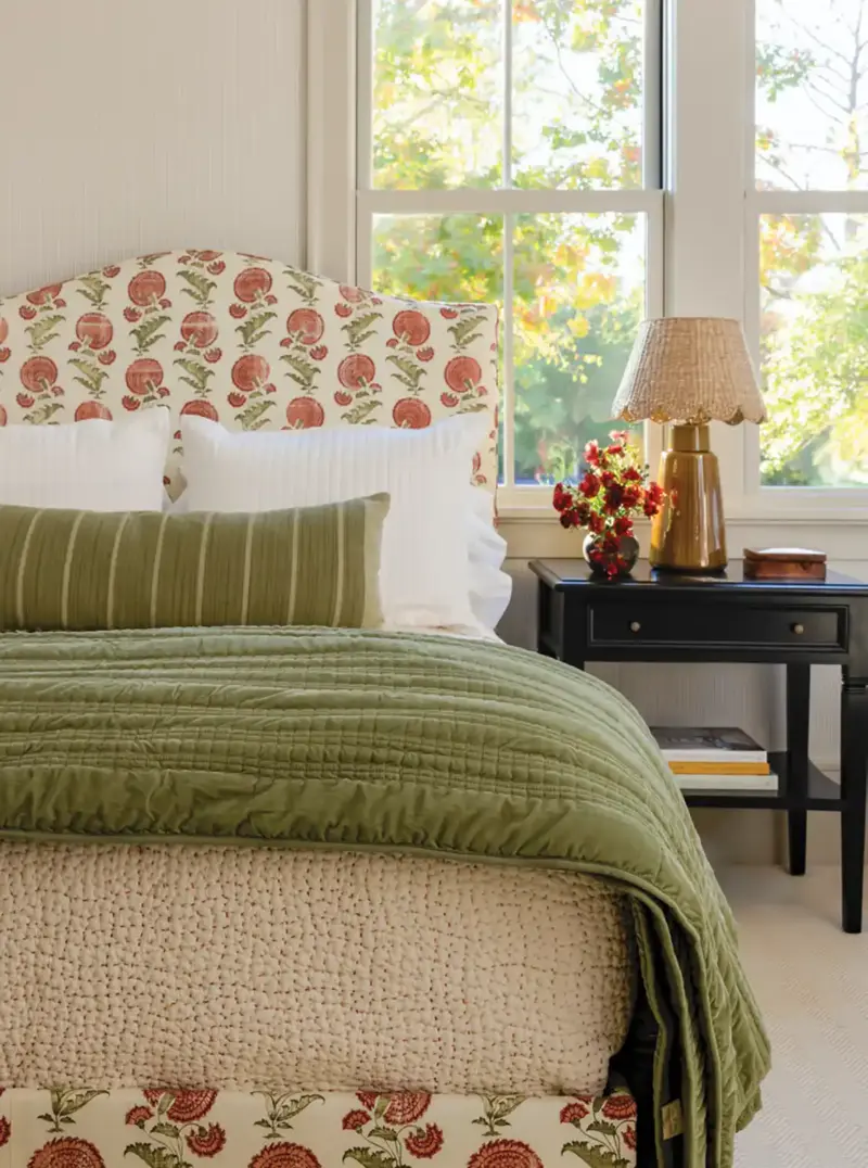 bedroom with green and beige bedding and block print apple bedframe