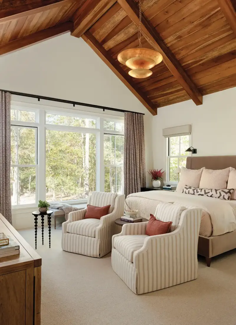 high vaulted wood ceiling and view to woods in peaceful bedroom