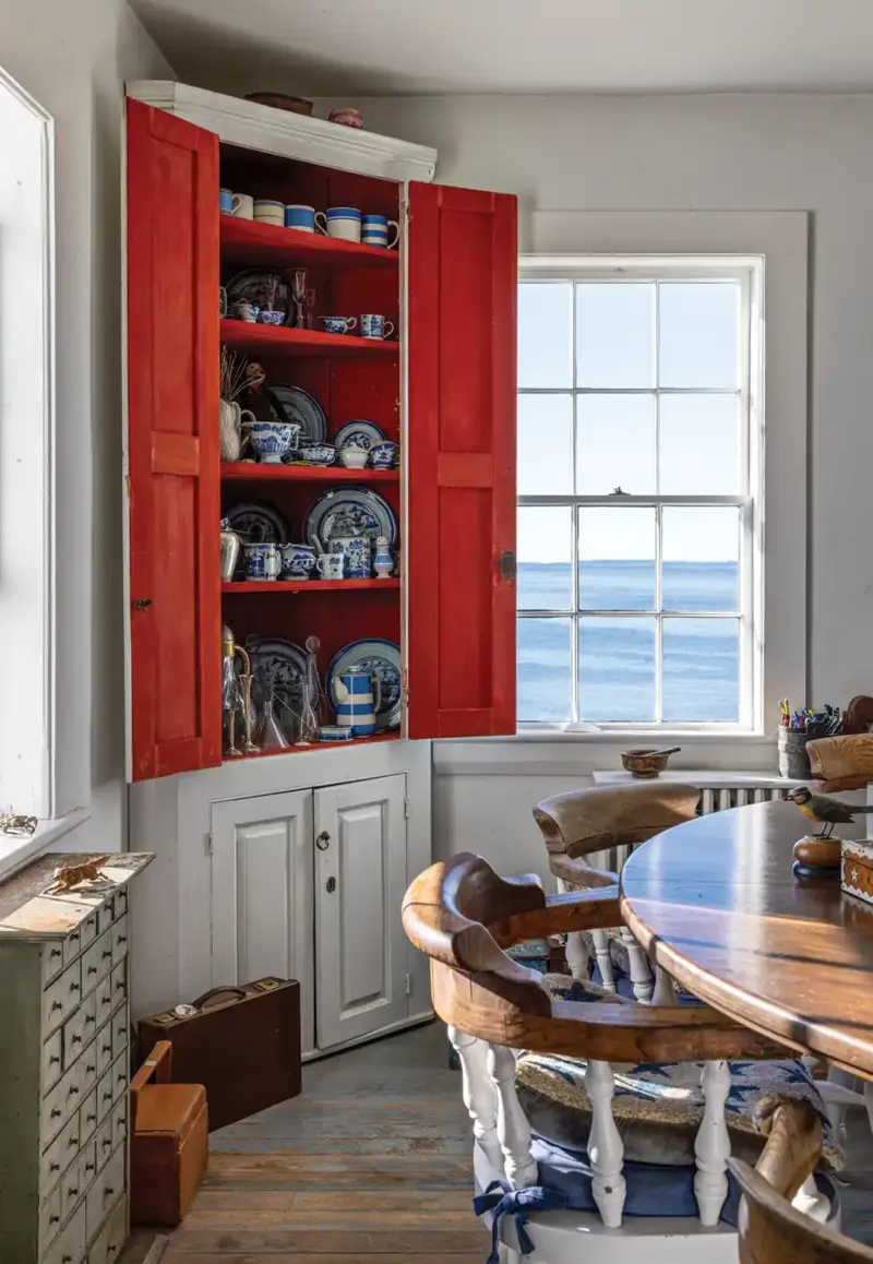 coastal Maine cottage with view to the ocean and hutch displaying white and blue china