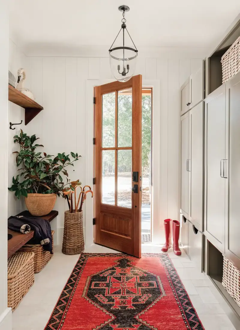 entryway with built-in storage cabinets and woven baskets