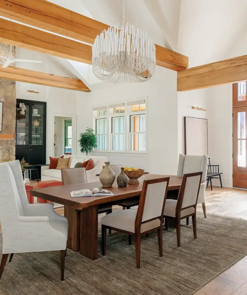 dining room with Arteriors modern chandelier and exposed wood beams in Mallard House