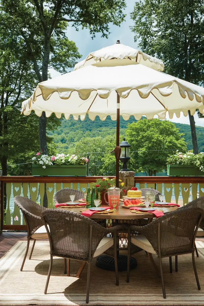 outdoor dining table on deck with vintage style umbrella with scalloped fringes