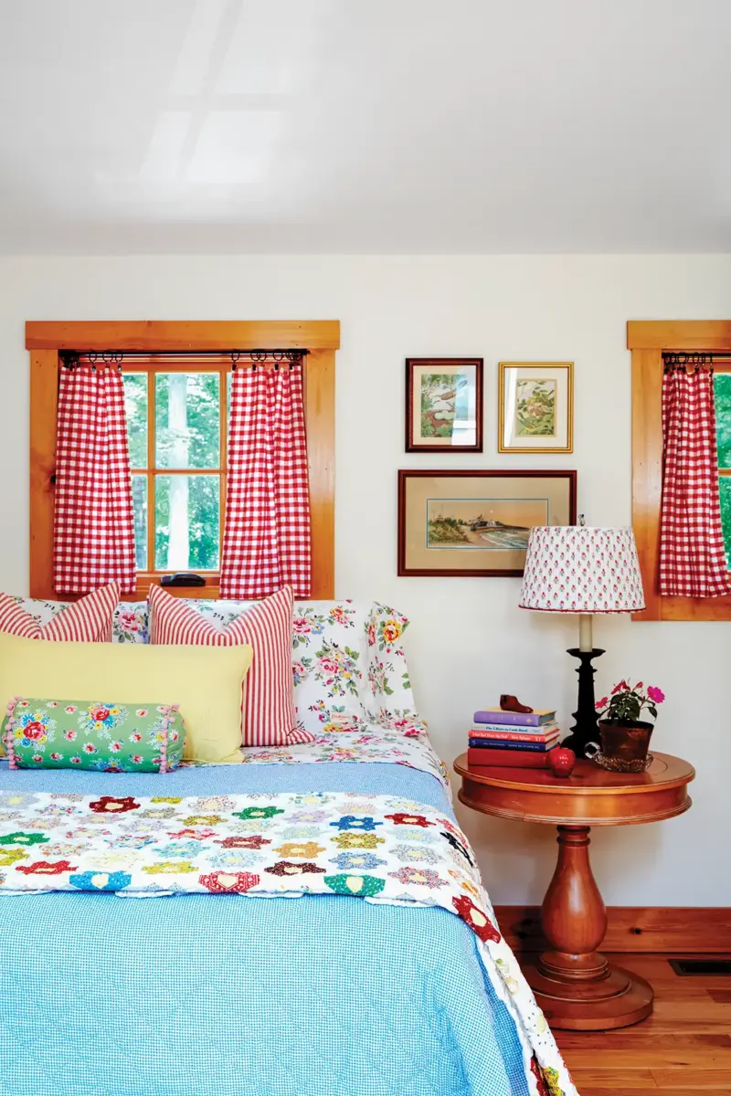 guest room with colorful bedding and red and white curtains