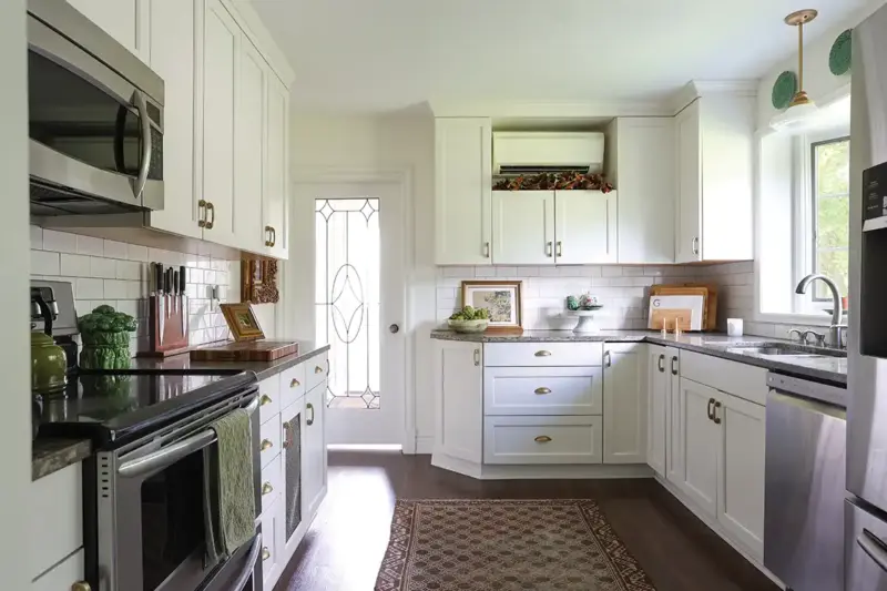 white kitchen with subway tile and stained glass in door in 1926 Tudor home