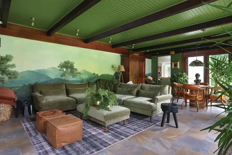 landscape mural on sunroom wall and green painted ceiling in Tudor home
