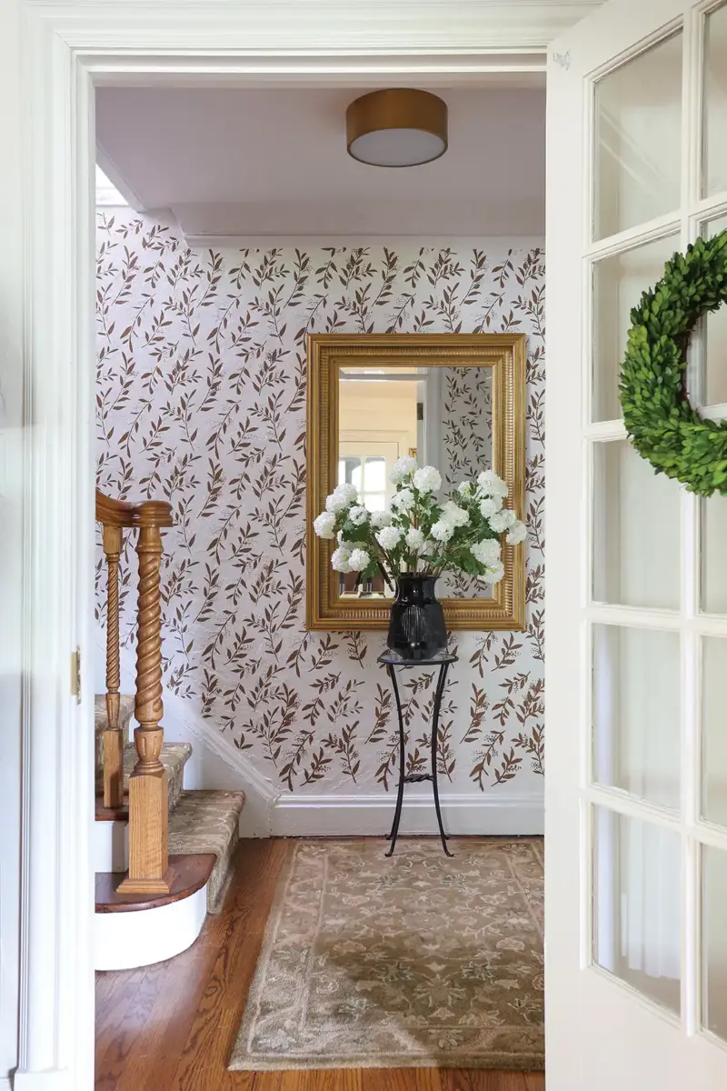 botanical stencil wall design with large framed mirror and bouquet of white hydrangeas.