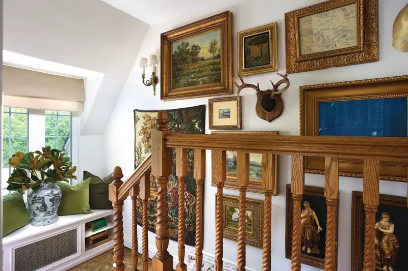 gallery wall along stairway with maps and paintings