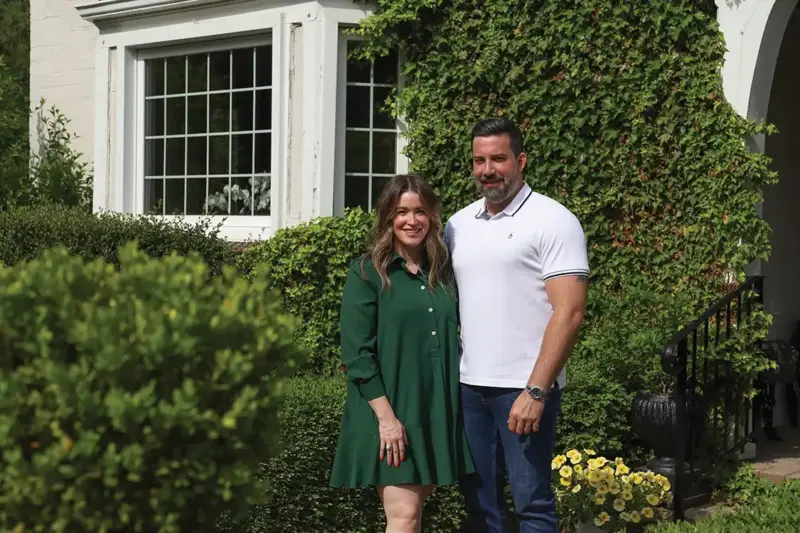 homeowners of the 1926 Tudor home refresh stand outside their home in Michigan