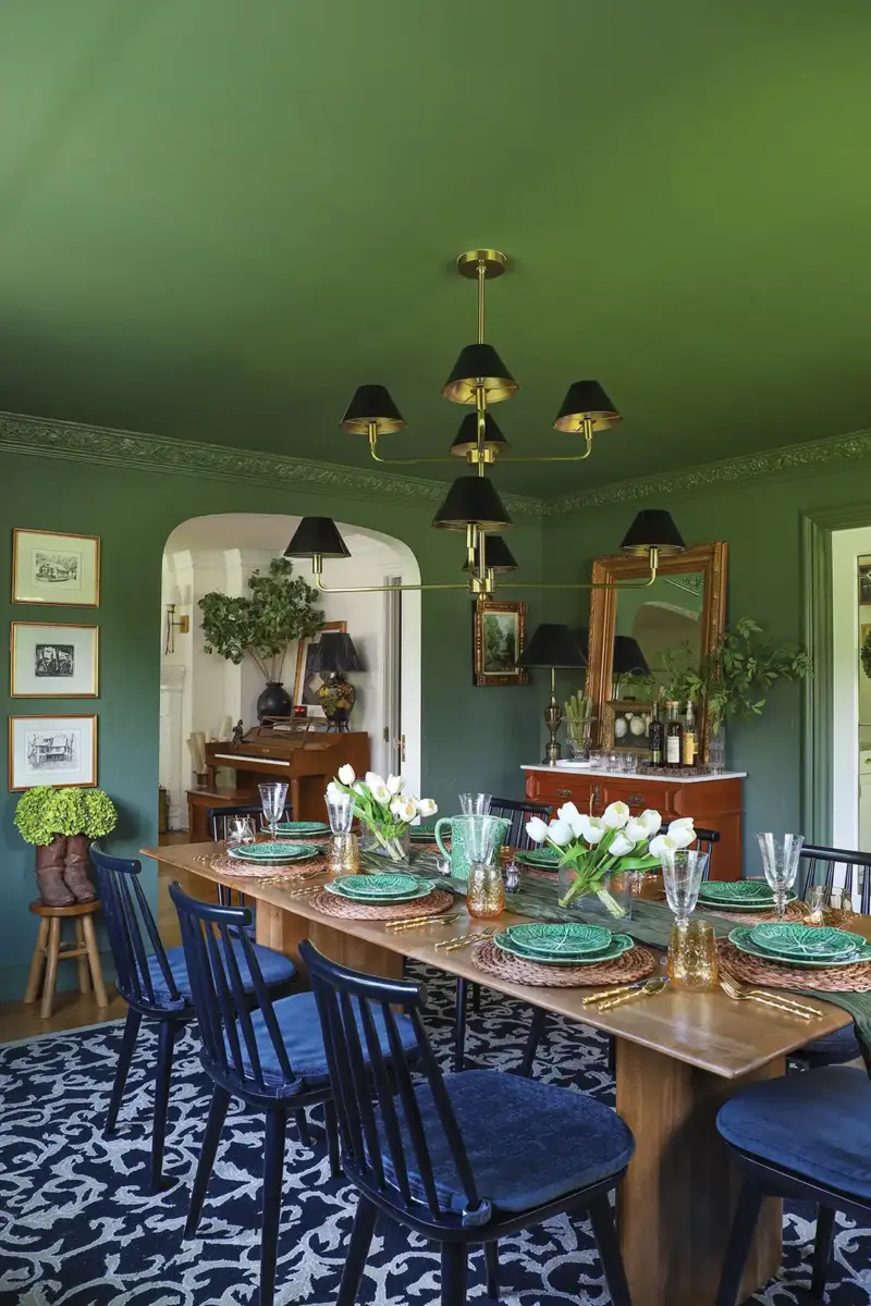 long angle view of dining room with black dining chairs and black chandelier lampshades in historic Tudor home
