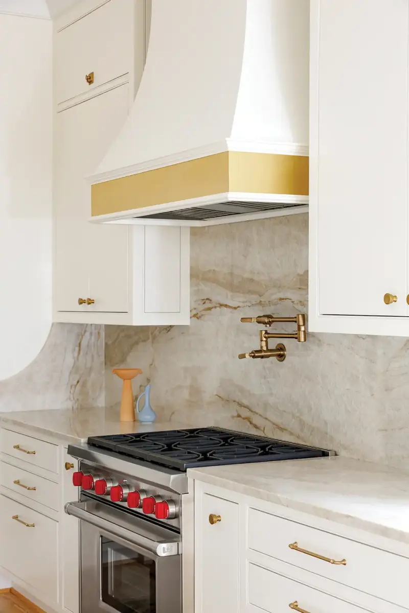 white range hood with gold border and marble backsplash