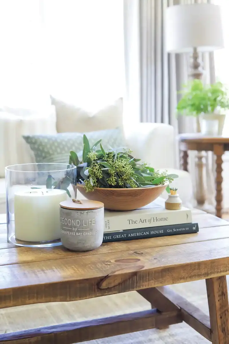 books, candles and freshly gathered leaves form a vignette in a meaningful home